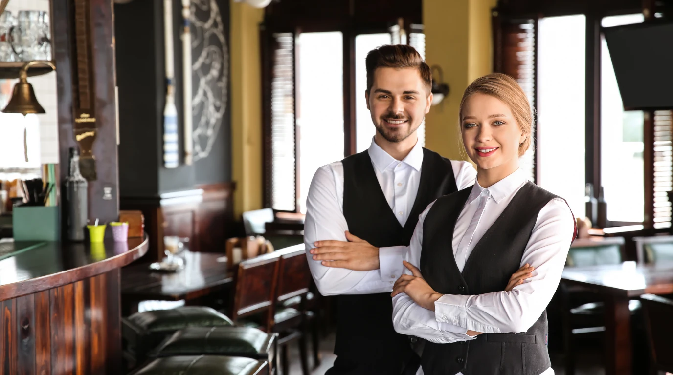 Restaurant servers ready to greet guests in a busy dining room